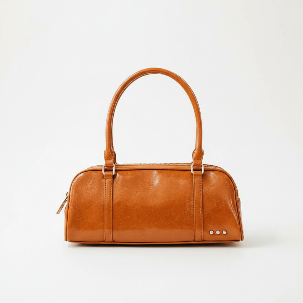 Annie Ks Boutique Arlys barrel shoulder bag in smooth caramel vegan leather with a top handle and structured design.