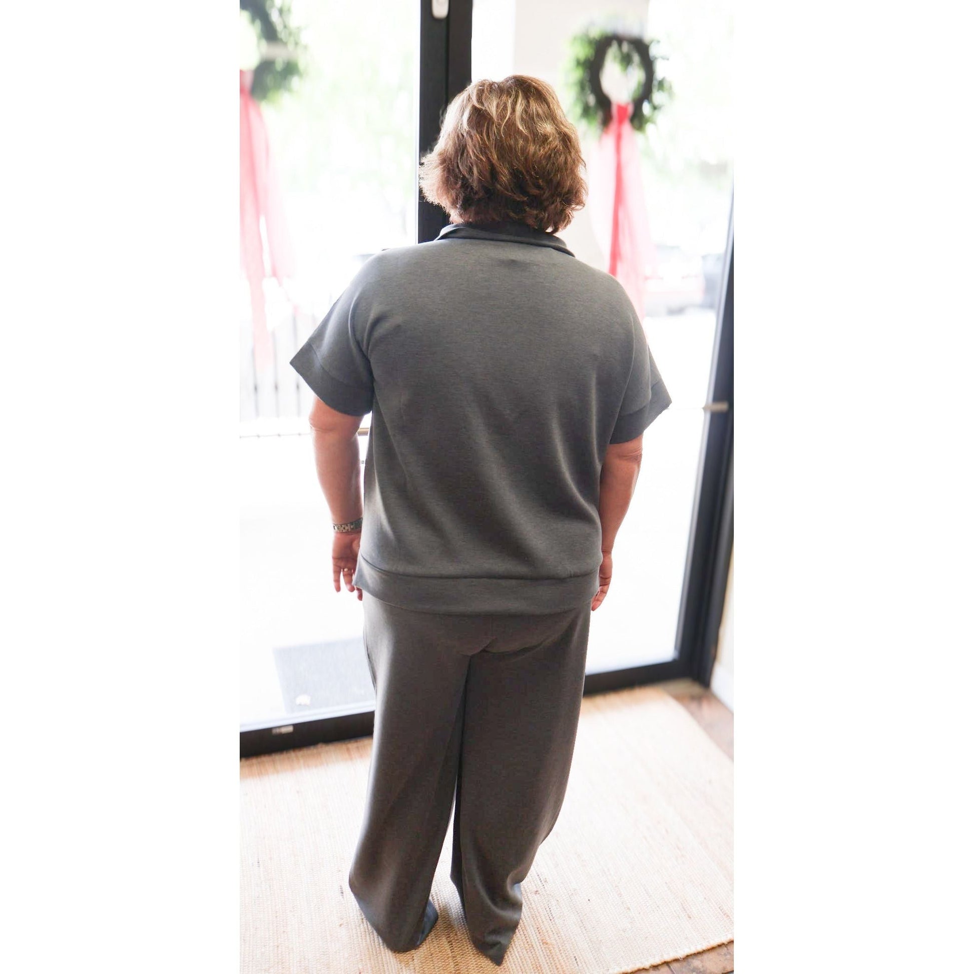 Back view of a woman wearing an Annie Ks Boutique charcoal scuba knit half-zip top and matching wide-leg pants set.