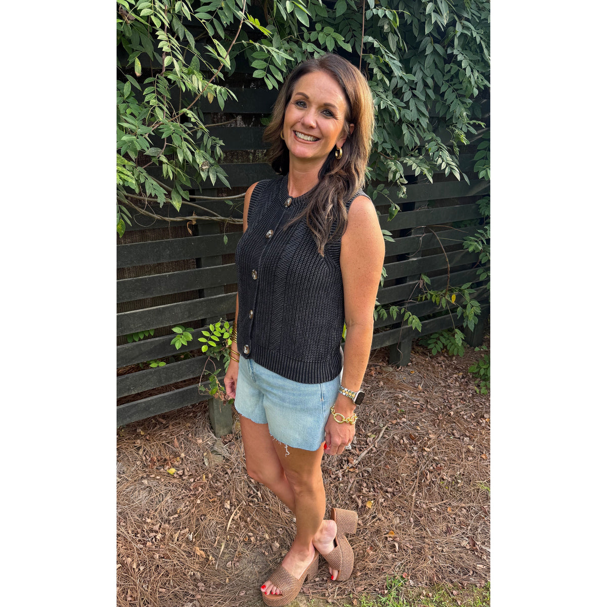 Annie Ks Boutique charcoal knitted cotton sweater vest with button front, worn by a woman with light denim shorts.