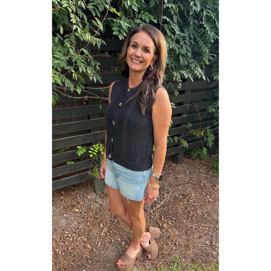Annie Ks Boutique charcoal knitted cotton sweater vest with button front, worn by a woman with light denim shorts.