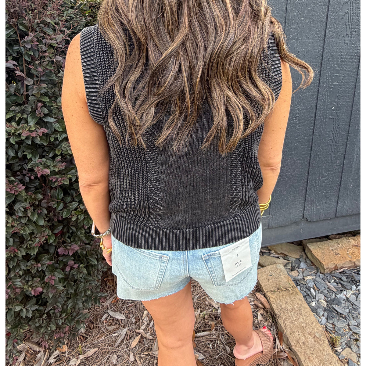 Annie Ks Boutique charcoal mineral-washed cotton sweater vest worn by a woman with long wavy hair, back view