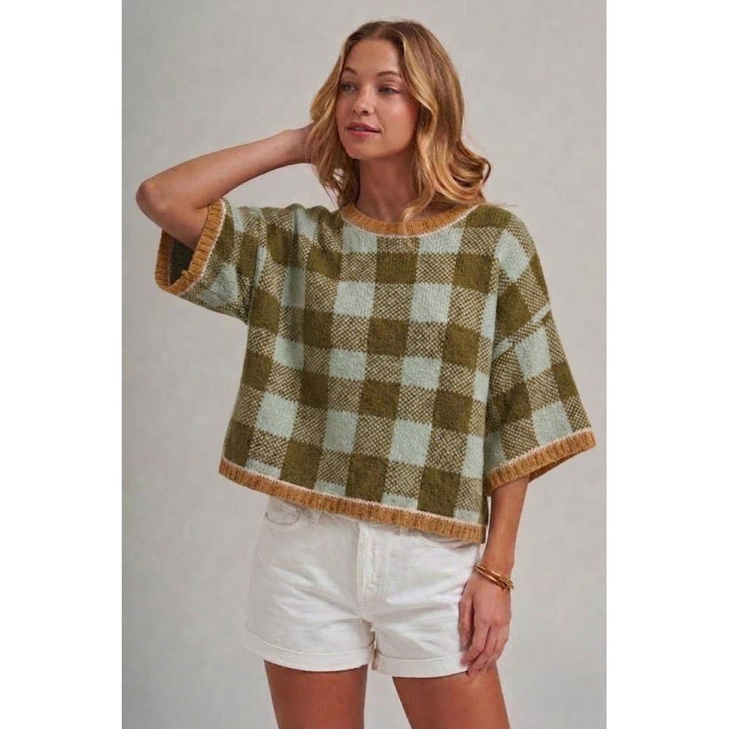 Annie Ks Boutique sage and olive checkered plush knit sweater with drop shoulders worn by a model with white shorts