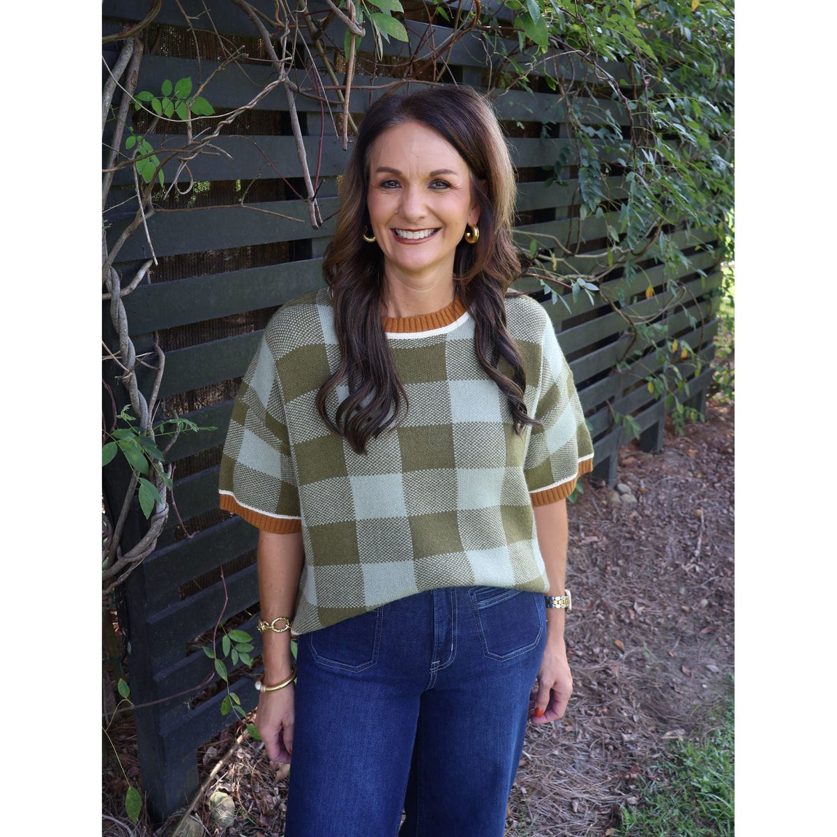 Annie Ks Boutique model wearing a sage and olive checkered plush knit sweater with drop shoulders and ribbed trim.