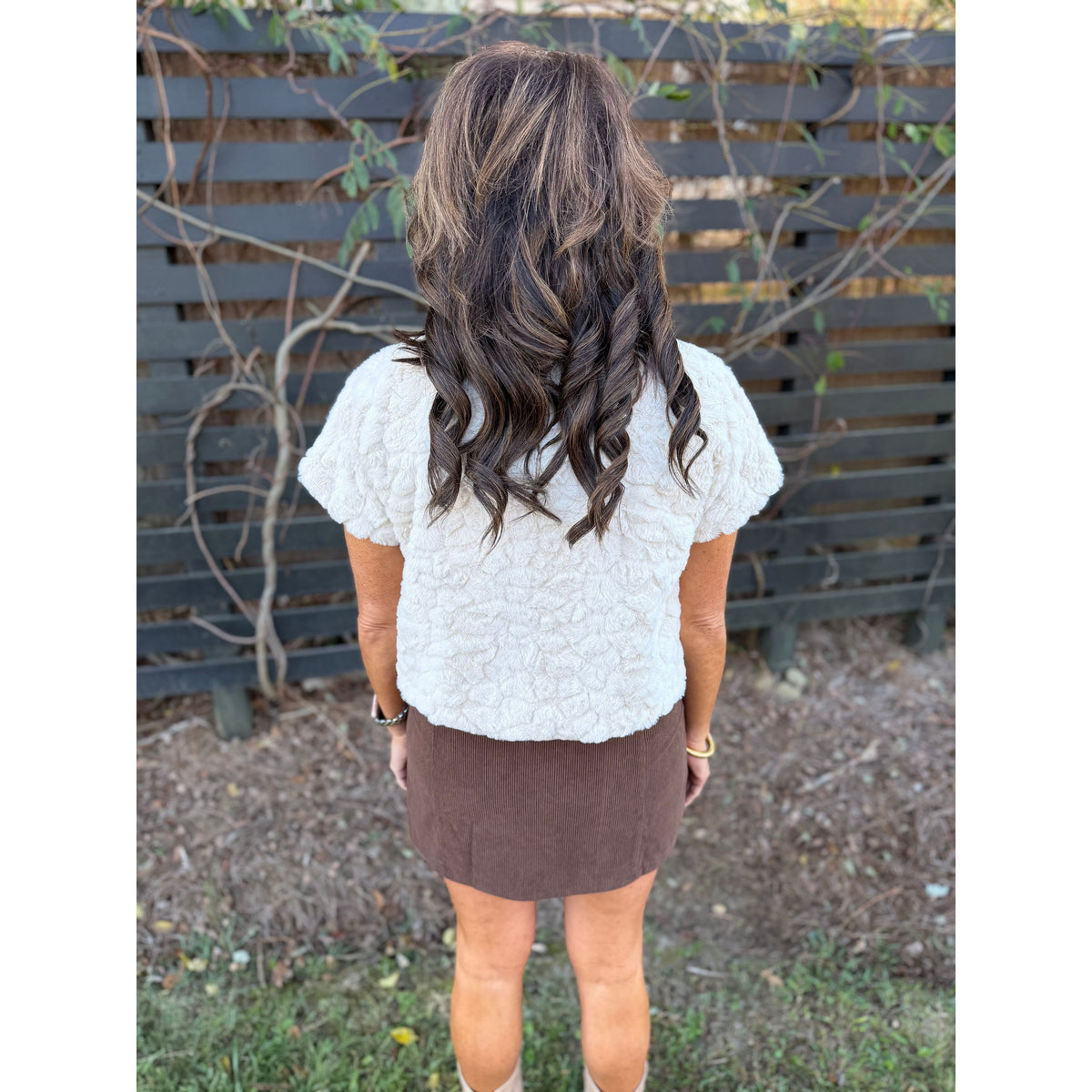 Annie Ks Boutique chocolate brown corduroy mini skirt paired with a textured cream short-sleeve top, back view.