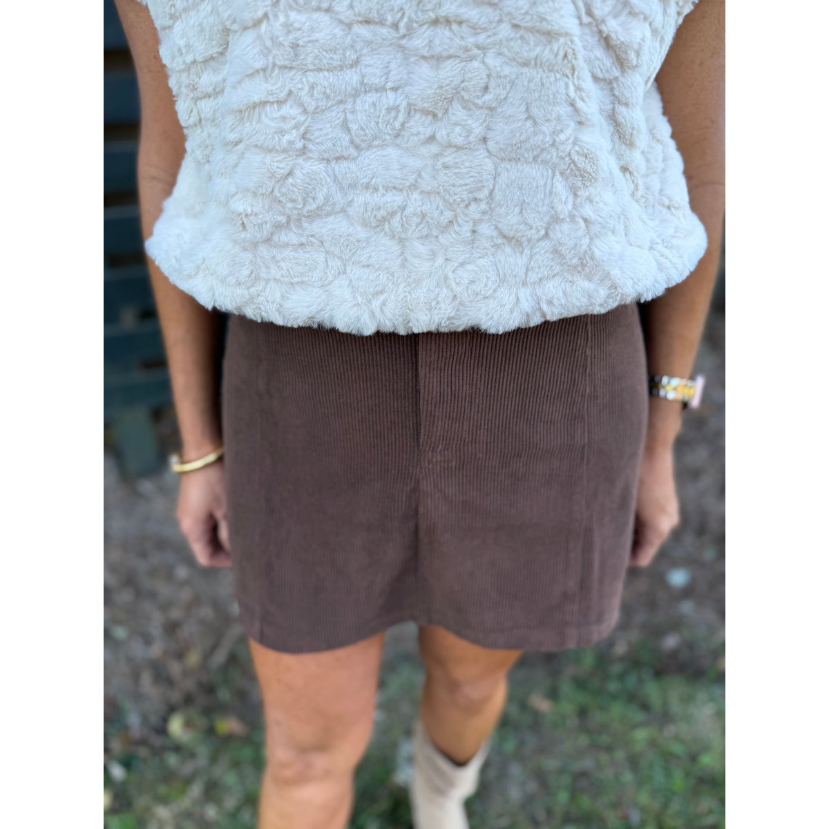 Annie Ks Boutique chocolate brown corduroy mini skirt in textured polyester fabric paired with a white faux fur top.