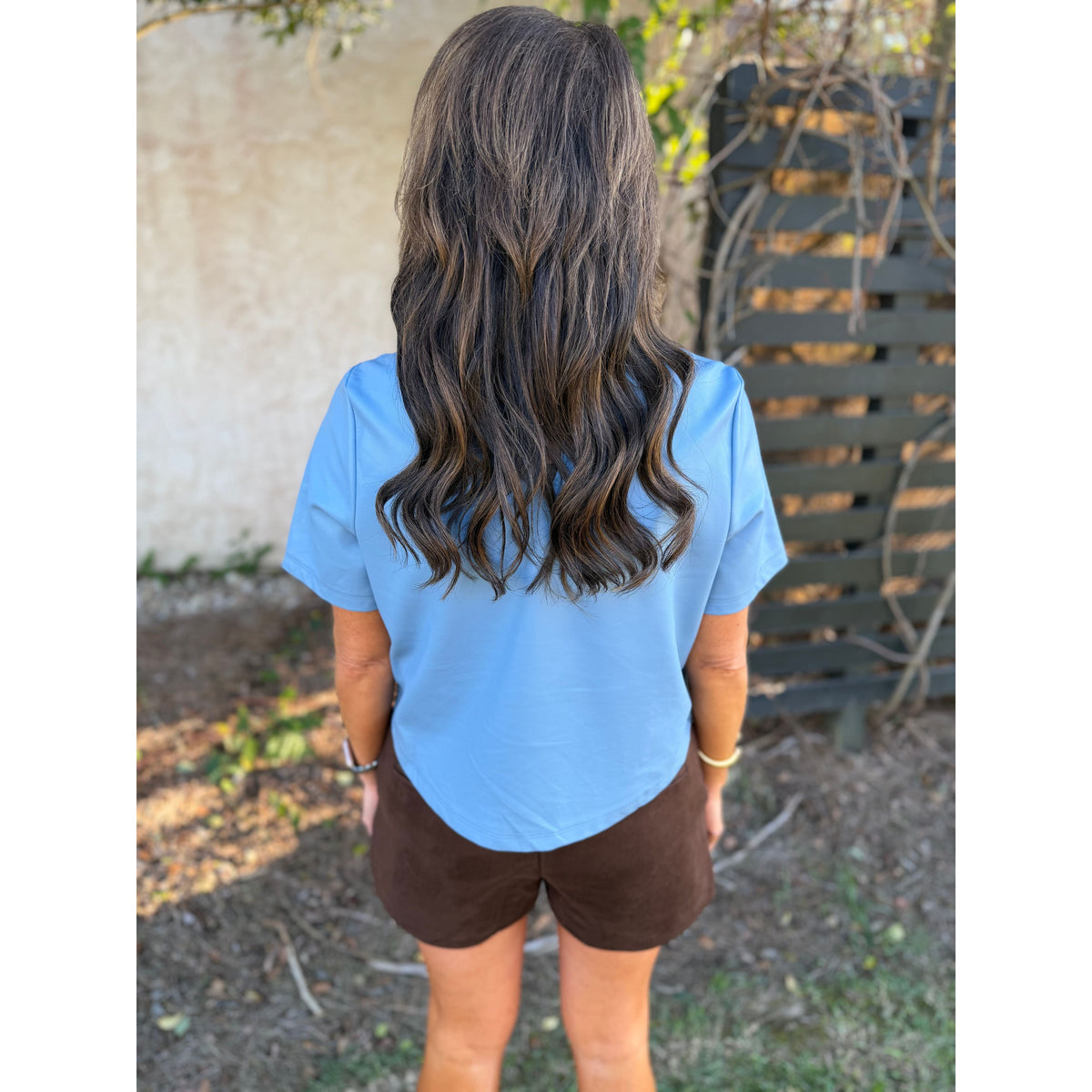 Annie Ks Boutique chocolate brown faux suede shorts with a relaxed fit and side pockets, worn with a blue top.