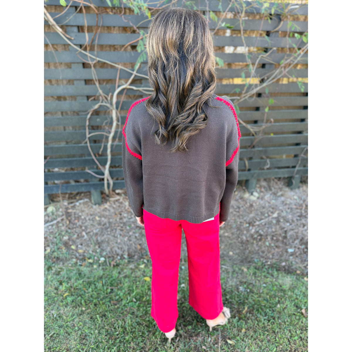 Annie Ks Boutique chocolate sweater with red blanket-stitch detail worn with red trousers, back view