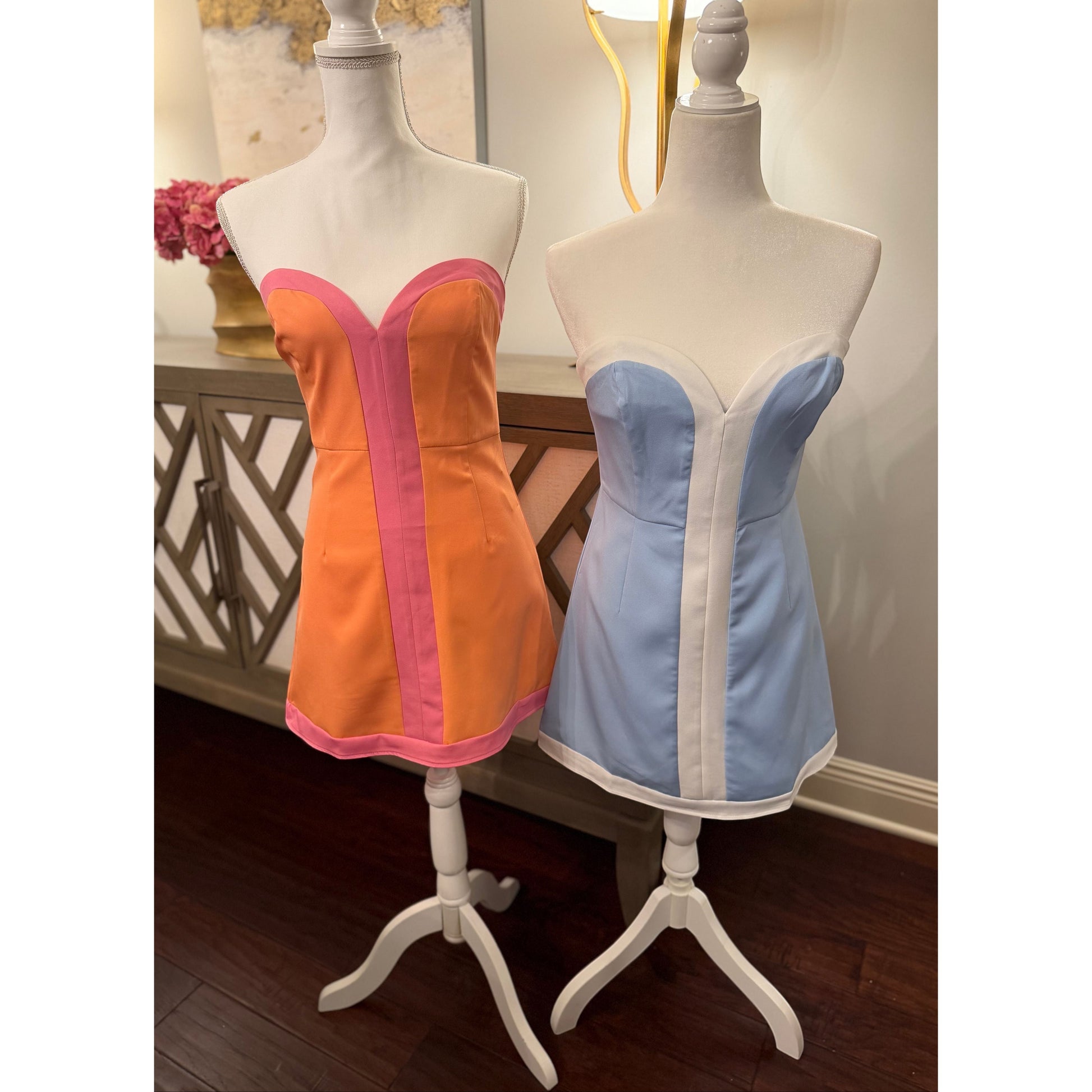 Annie Ks Boutique strapless colorblock romper dresses in peach-pink and powder blue on display on mannequins.