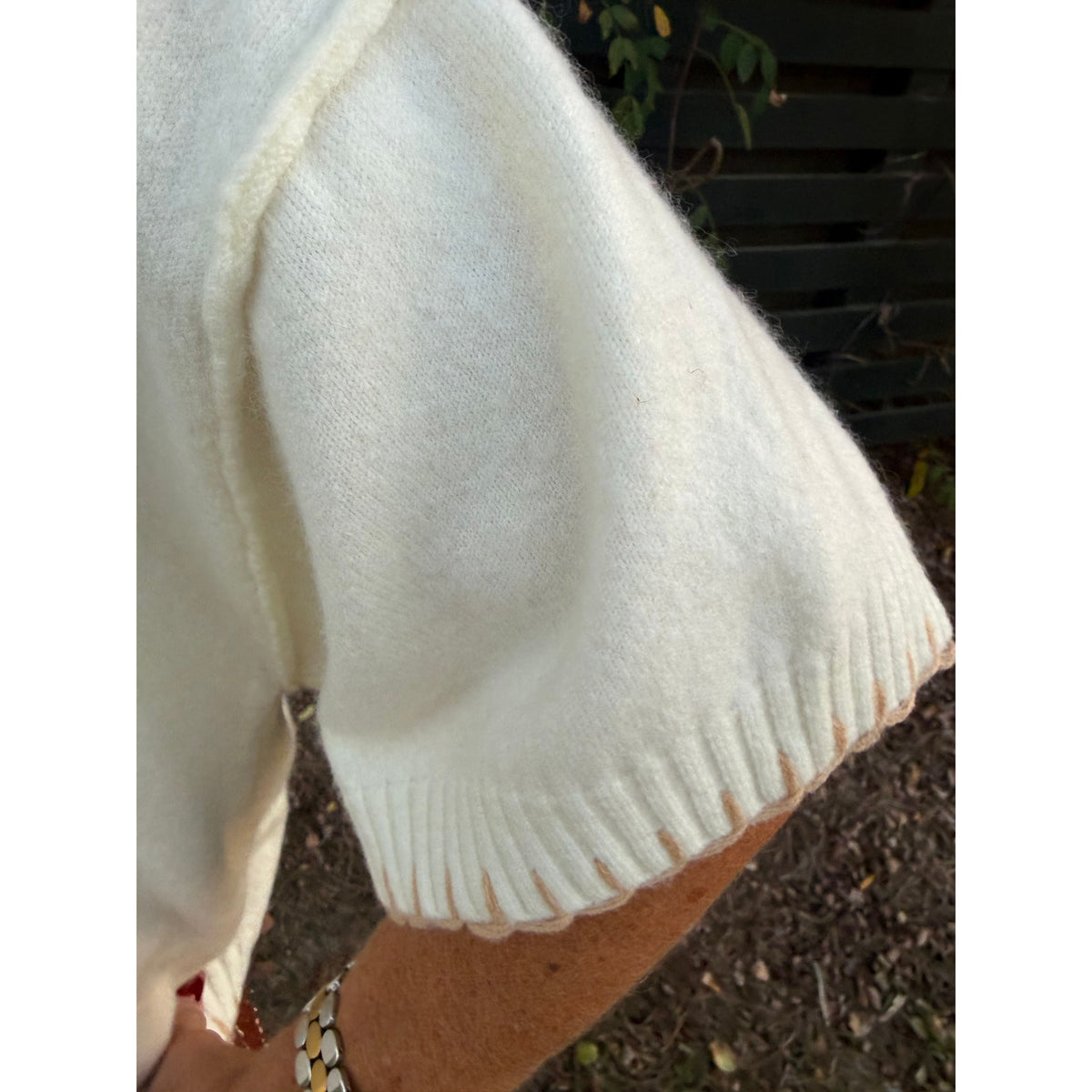 Annie Ks Boutique white and beige short sleeve sweater featuring contrast blanket stitching on the ribbed cuff