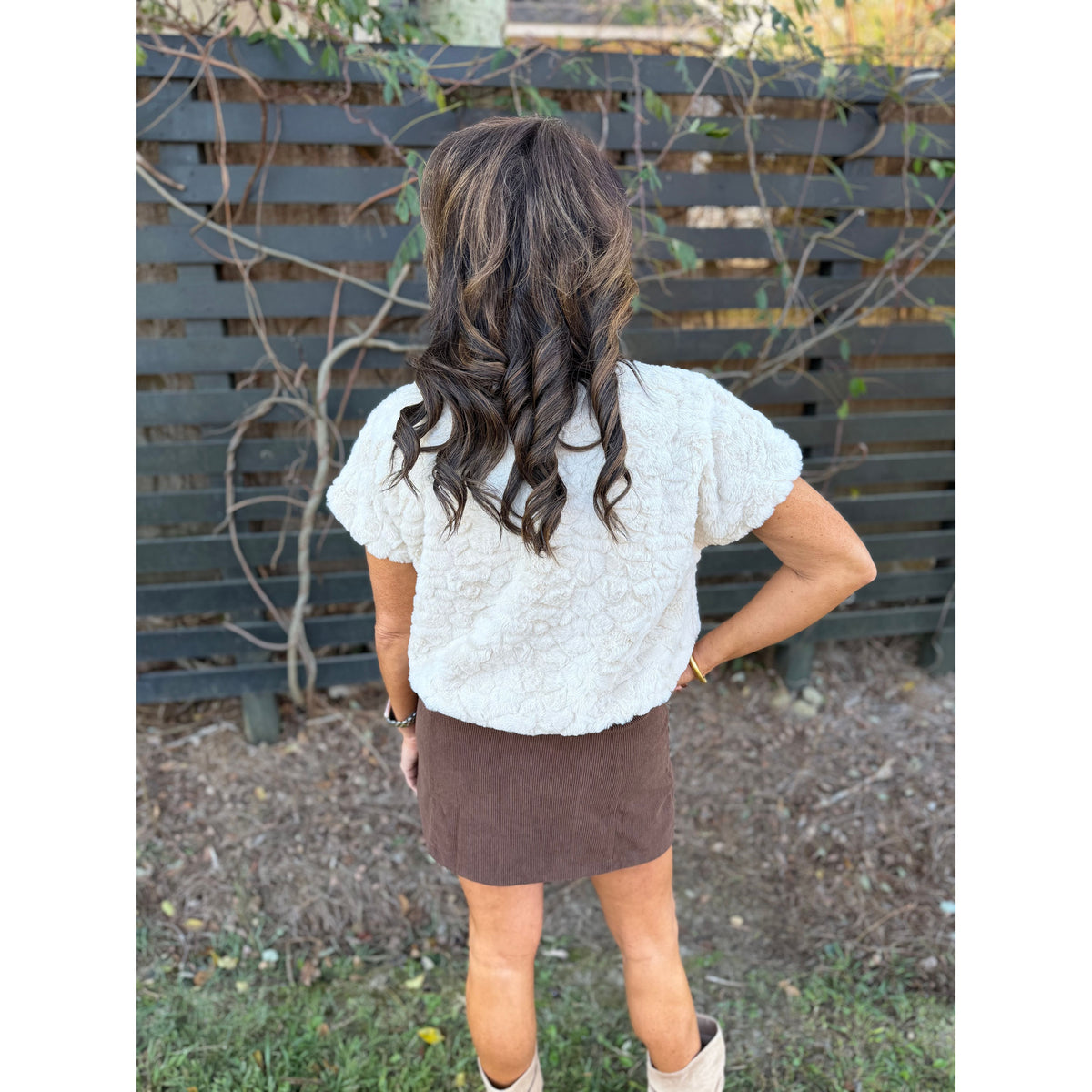 Annie Ks Boutique cream faux-fur short sleeve top worn with a brown corduroy skirt, back view