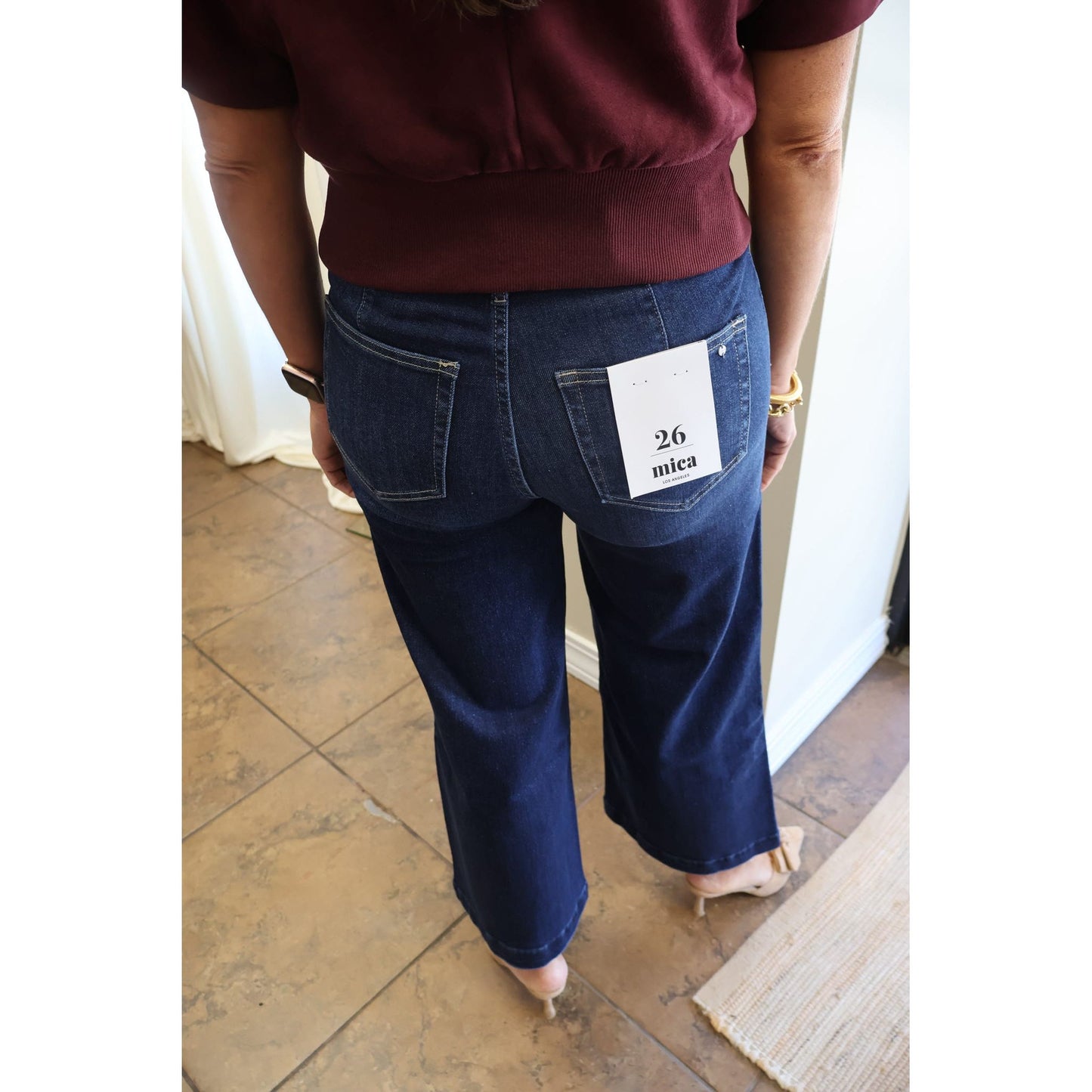 Annie Ks Boutique dark wash high-rise wide leg crop jeans worn by a model with a burgundy top and beige mules.