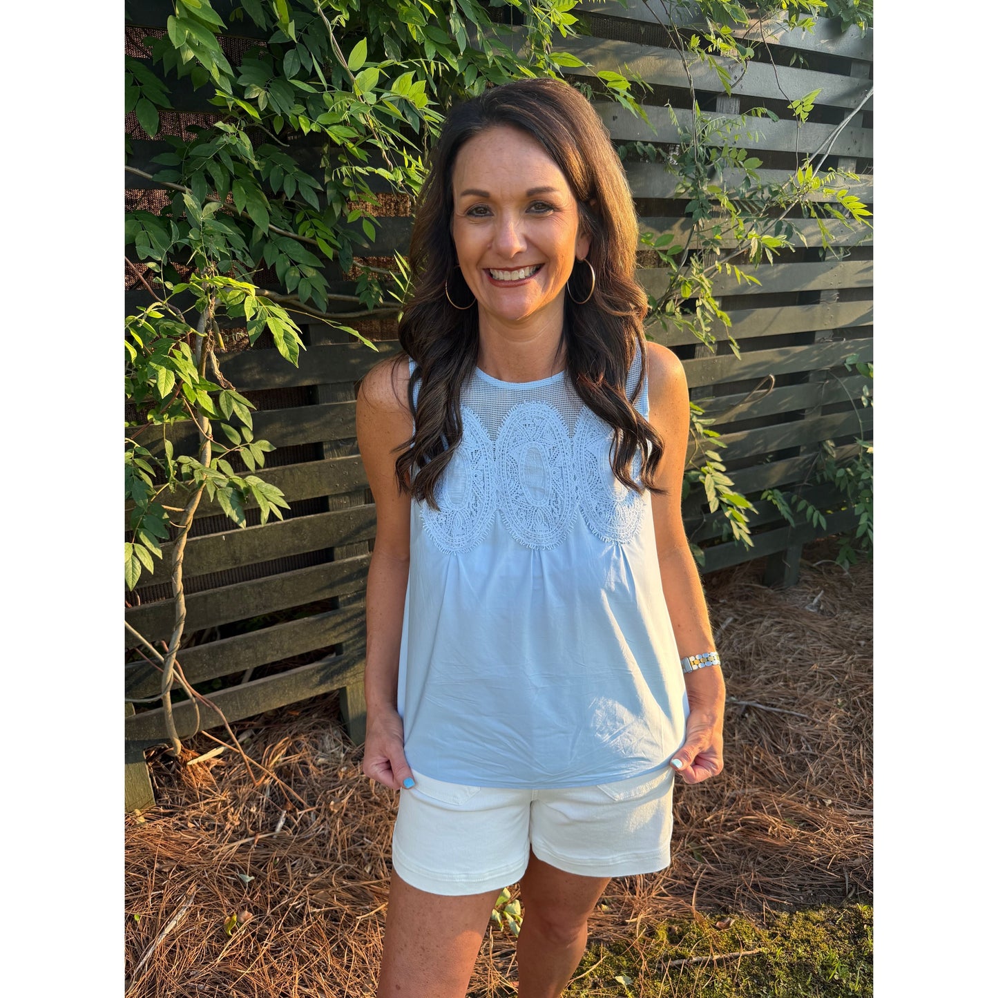 Annie Ks Boutique dusty blue cotton sleeveless top with mesh yoke and lace trim worn by a smiling woman outdoors.