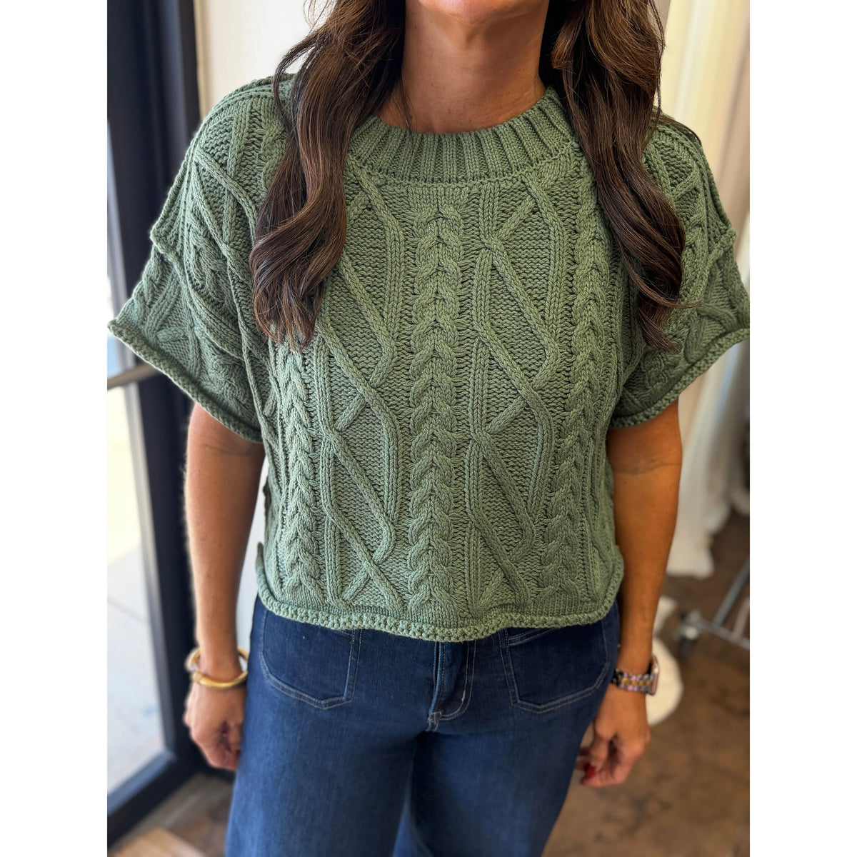 Annie Ks Boutique dusty green cropped knit sweater with cable knit texture and round neckline on a model
