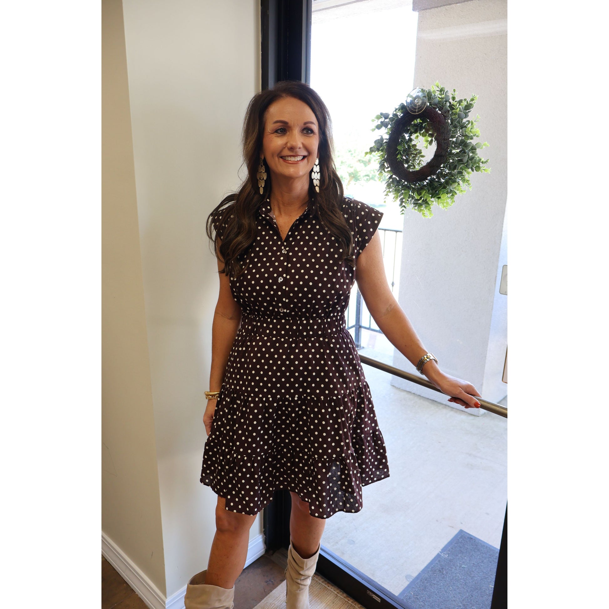 Annie Ks Boutique espresso brown cotton mini dress with white polka dots, tiered skirt, and collar, worn with boots.