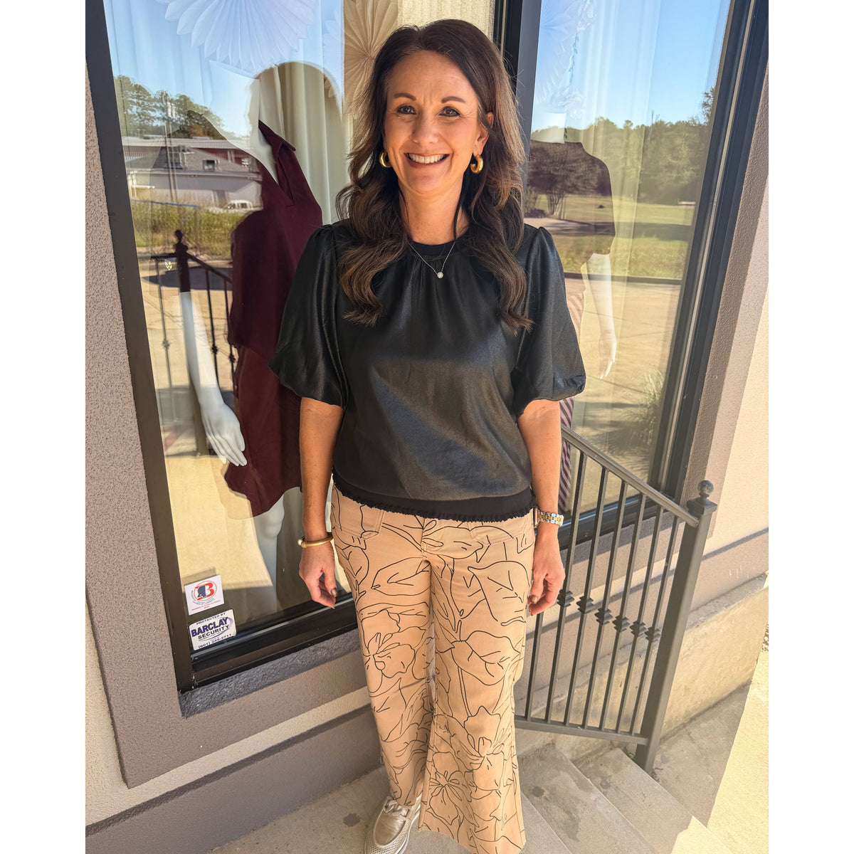 Annie Ks Boutique model wearing monochrome floral print wide-leg cropped jeans and a black puff-sleeve top