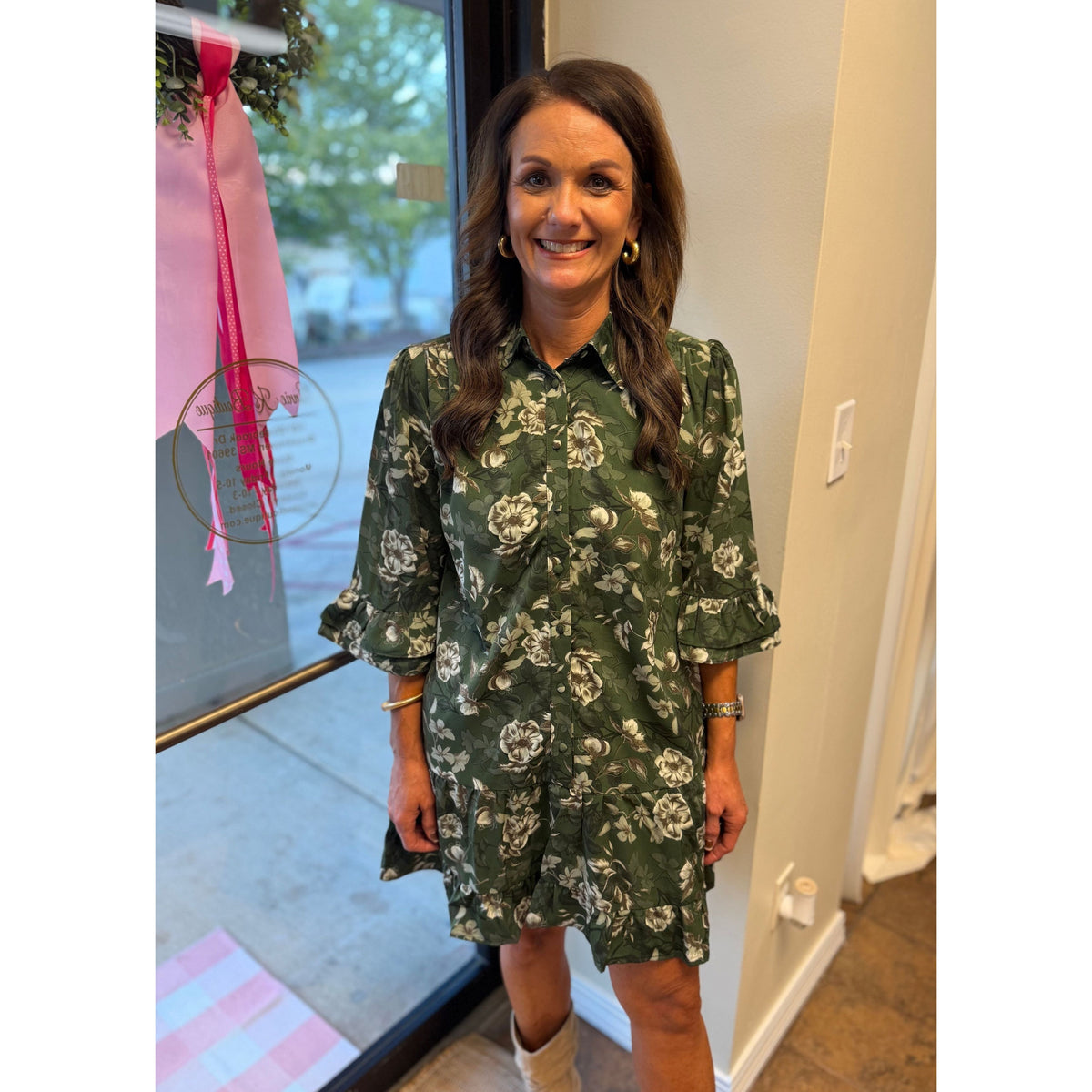 Annie Ks Boutique green floral mini dress with ruffle sleeves, button-down front, and patch pockets on a woman
