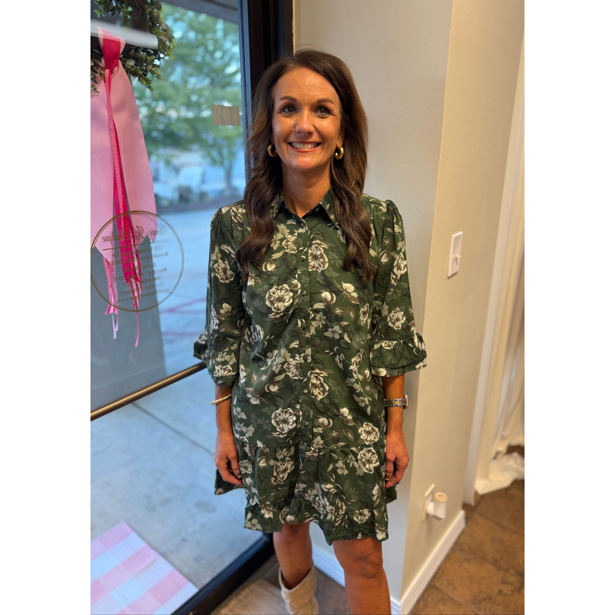 Annie Ks Boutique green floral mini dress with ruffle hem, button-down front, and patch pockets worn by a woman
