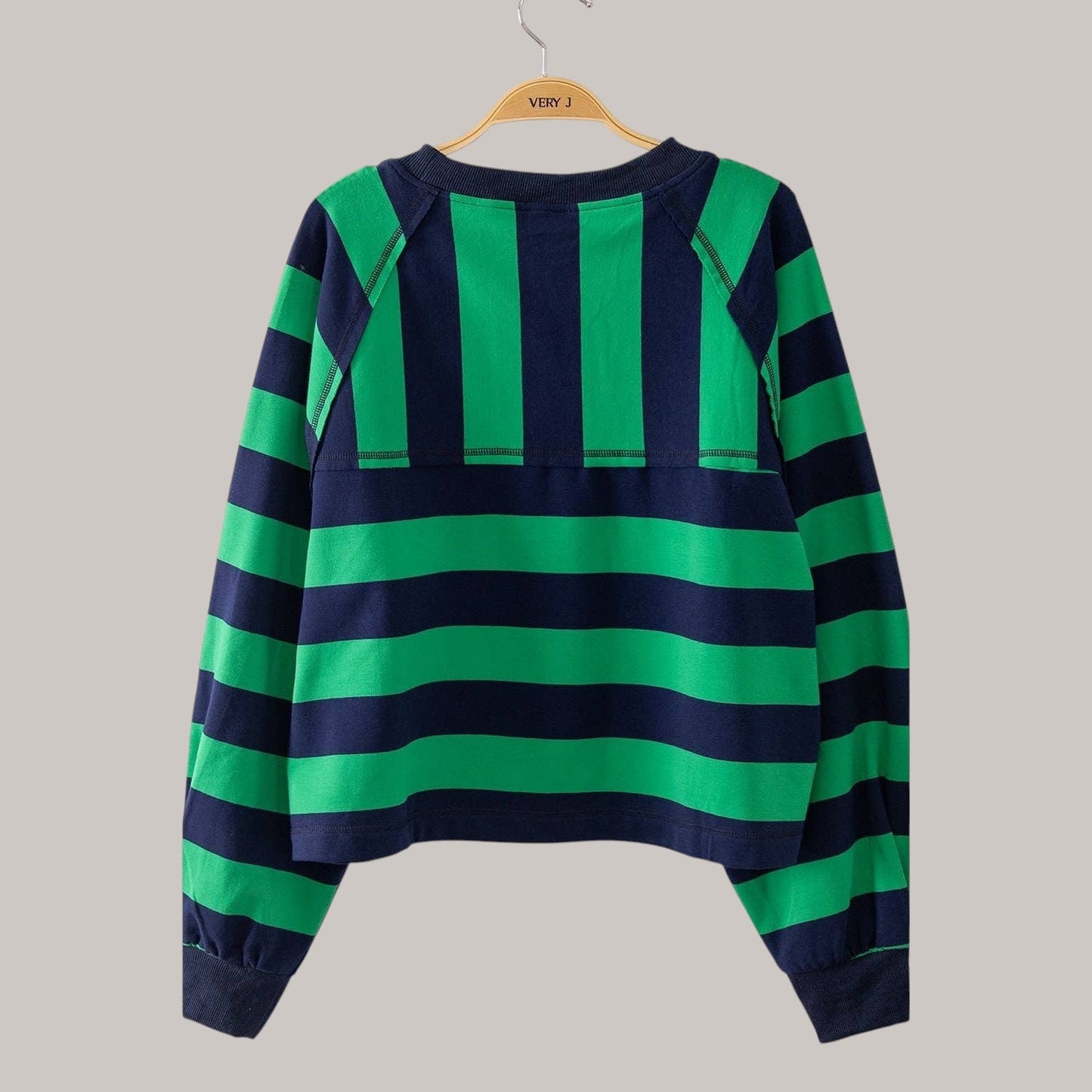 Annie Ks Boutique green and navy striped casual top with a contrast yoke panel and raglan sleeves on a hanger