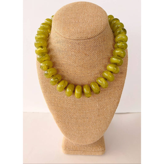 Annie Ks Boutique green rondelle beaded necklace with a glossy finish displayed on a beige fabric mannequin bust.