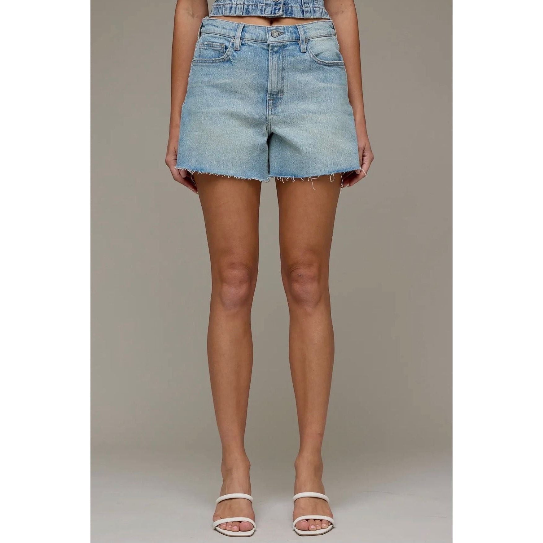 Annie Ks Boutique high-rise denim shorts in a light vintage wash with a raw hem and relaxed A-line fit on a model.
