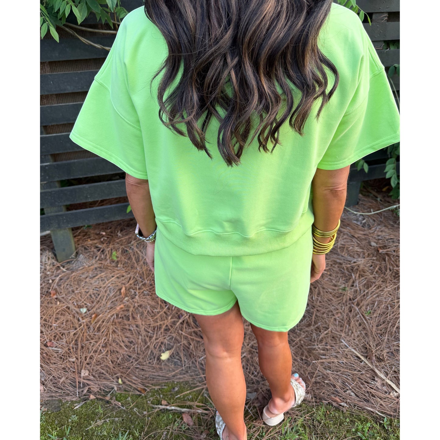 Annie Ks Boutique key lime green cotton blend short set worn by a woman from behind in an outdoor setting.