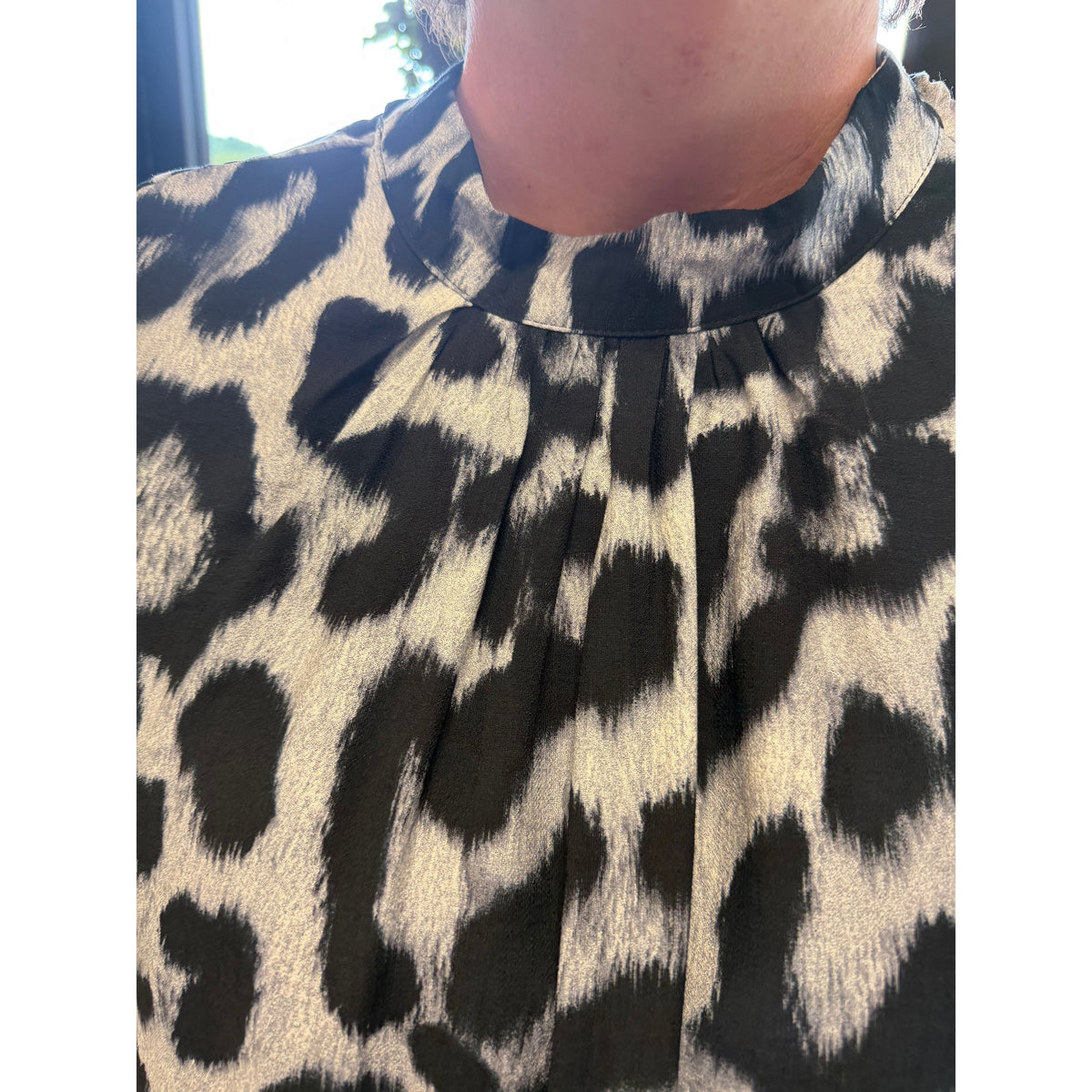 Annie Ks Boutique curvy leopard print mock neck blouse in black with a soft viscose blend and pleated neckline.