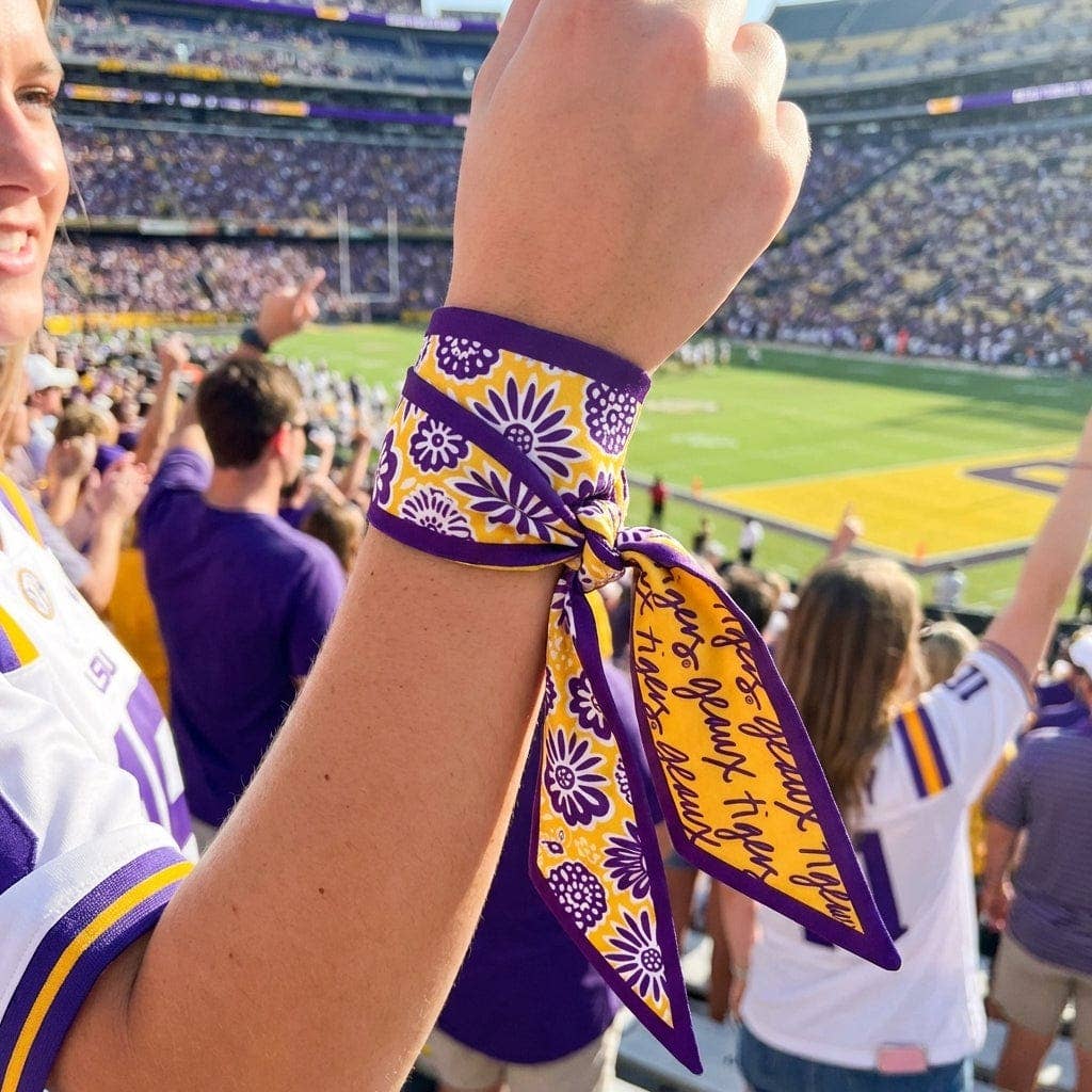 Annie Ks Boutique LSU Tigers satin skinny scarf tied as a wrist accessory at a football stadium