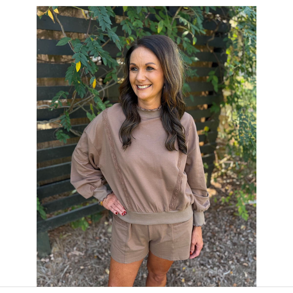 Annie Ks Boutique mocha lounge set with a cropped lace trim sweatshirt and matching shorts worn by a smiling woman.