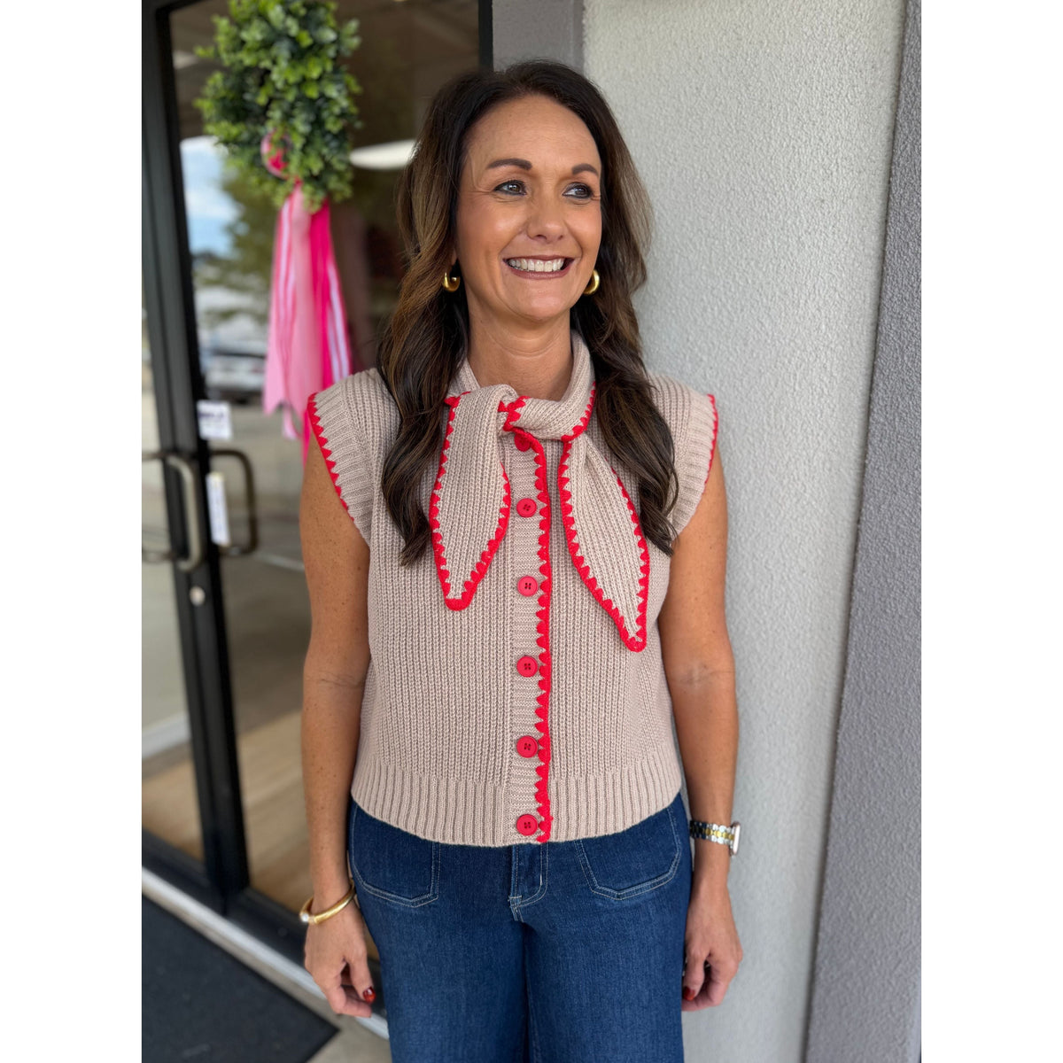 Annie Ks Boutique mocha sweater vest with red contrast blanket stitching, button front, and tie neck detail.
