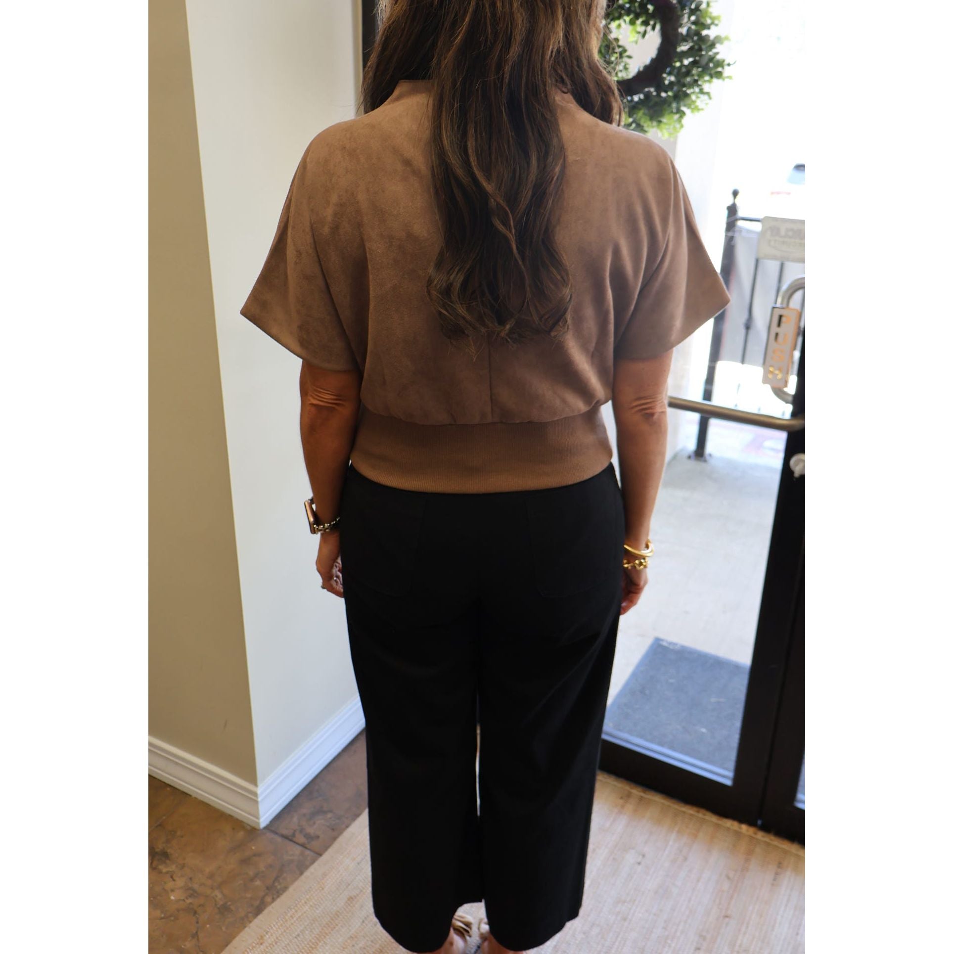 Annie Ks Boutique mocha suede-look mock neck top with short sleeves worn by a woman from the back view