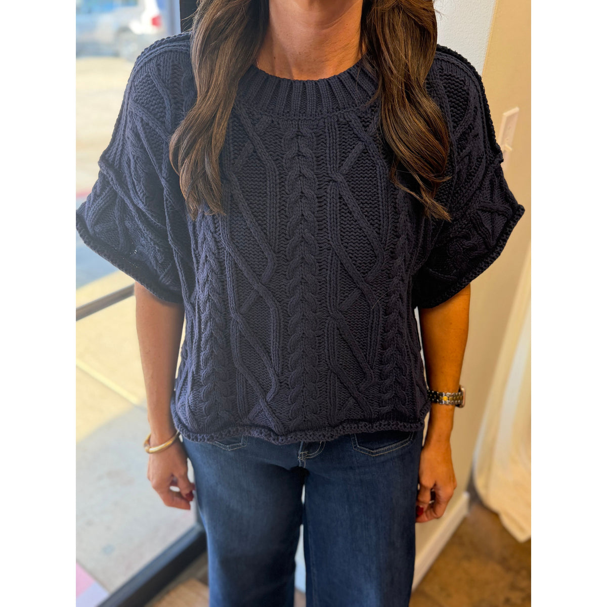 Annie Ks Boutique navy blue cropped knit sweater with cable knit texture and short sleeves worn with jeans
