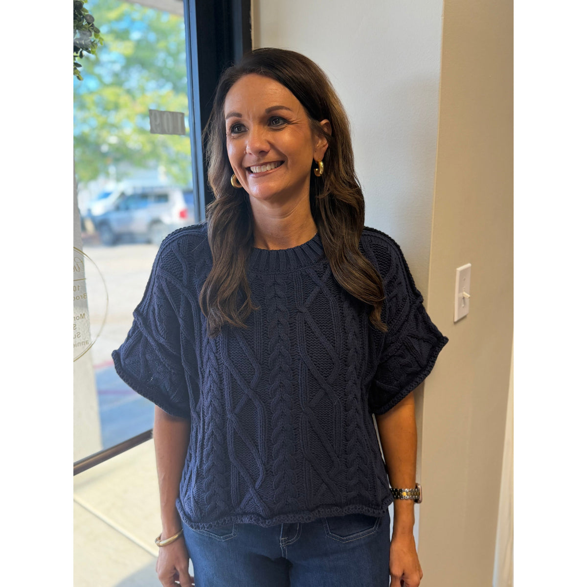 Annie Ks Boutique model wearing a navy blue cropped cable knit sweater with a round neckline and boxy fit.
