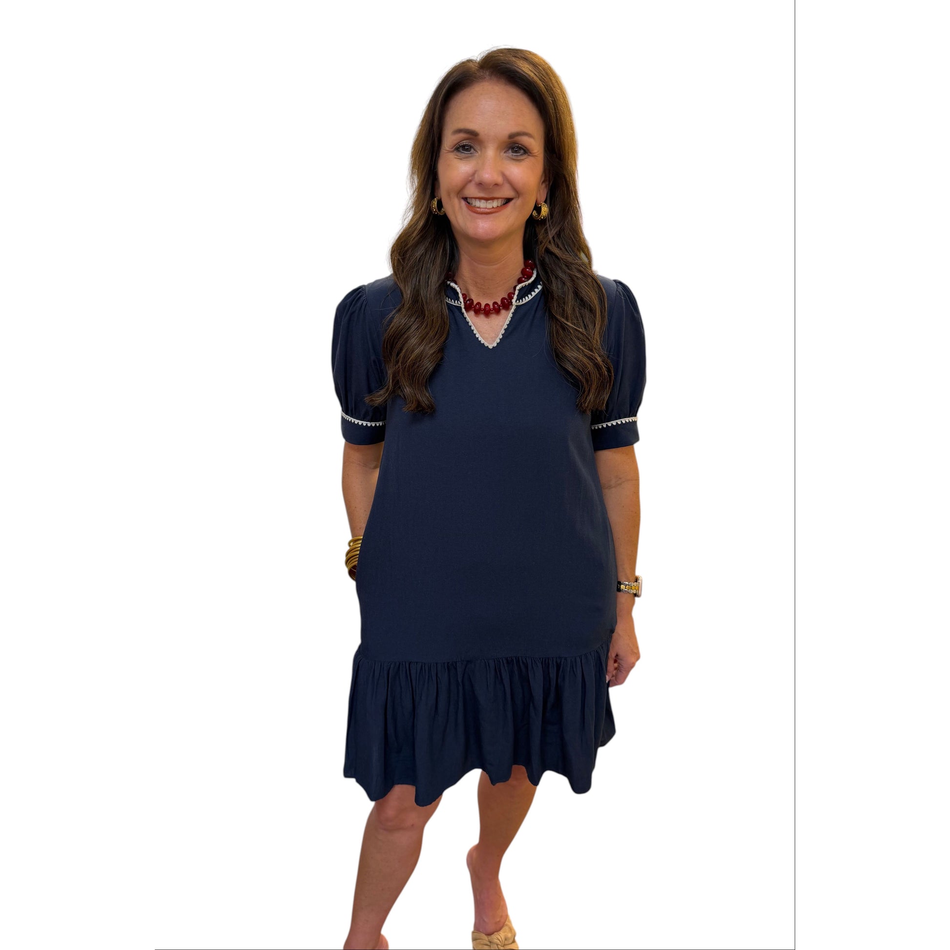 Annie Ks Boutique navy shift dress with puff sleeves, contrast embroidery trim, and side pockets worn by a model.