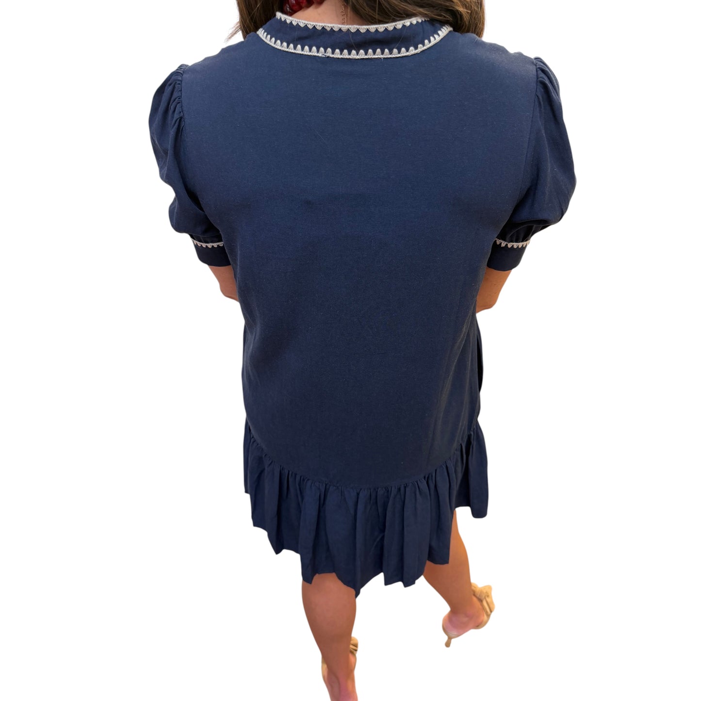 Annie Ks Boutique navy shift dress with puff sleeves, contrast embroidery trim, and a ruffled hem, back view.
