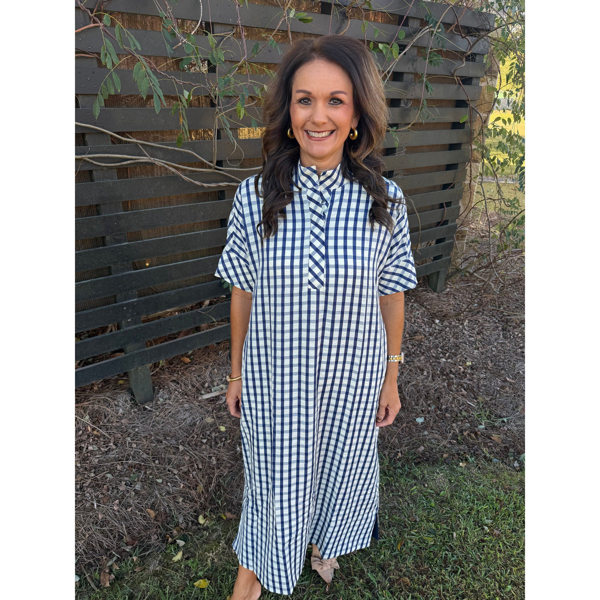 Annie Ks Boutique navy and white gingham midi dress with short sleeves, shirt collar, and pockets on a smiling woman.
