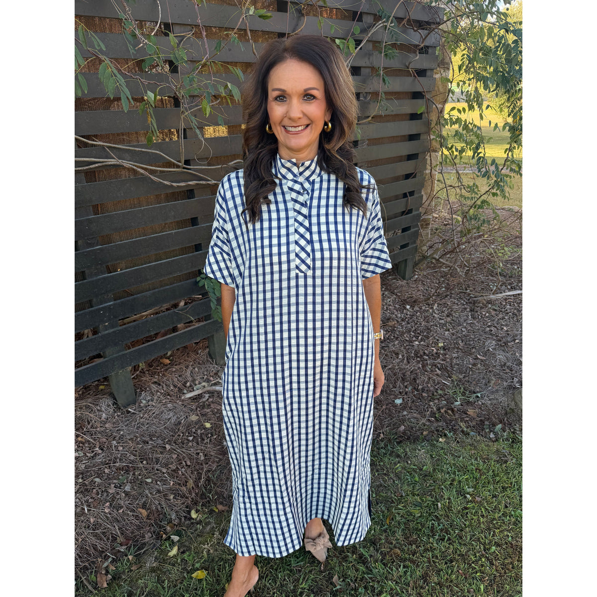 Annie Ks Boutique navy and white gingham midi dress with short sleeves, shirt collar, and side pockets on a woman.
