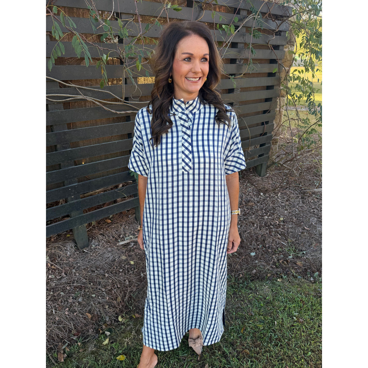 Annie Ks Boutique navy and white gingham midi dress with short sleeves, shirt collar, and pockets on a smiling woman.