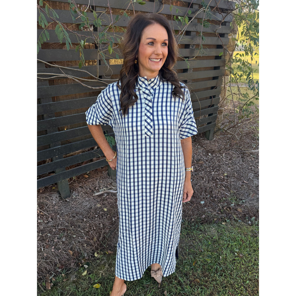 Annie Ks Boutique navy and white gingham midi dress with short sleeves, shirt collar, and pockets on a smiling woman.