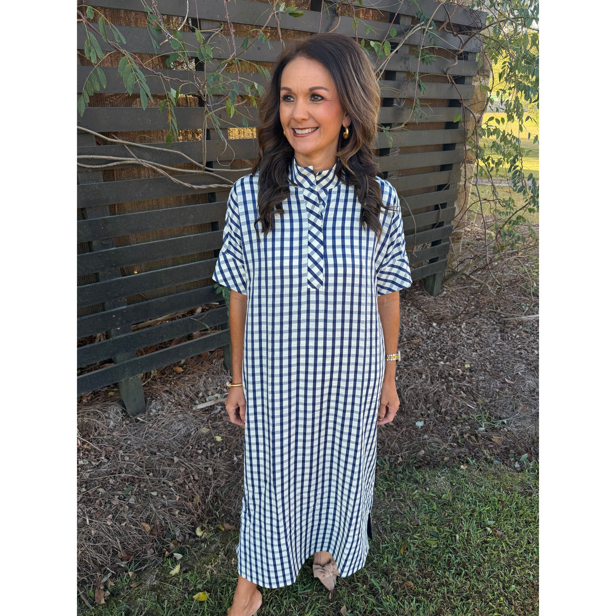 Annie Ks Boutique navy and white gingham midi dress with short sleeves, shirt collar, and pockets on a smiling woman.
