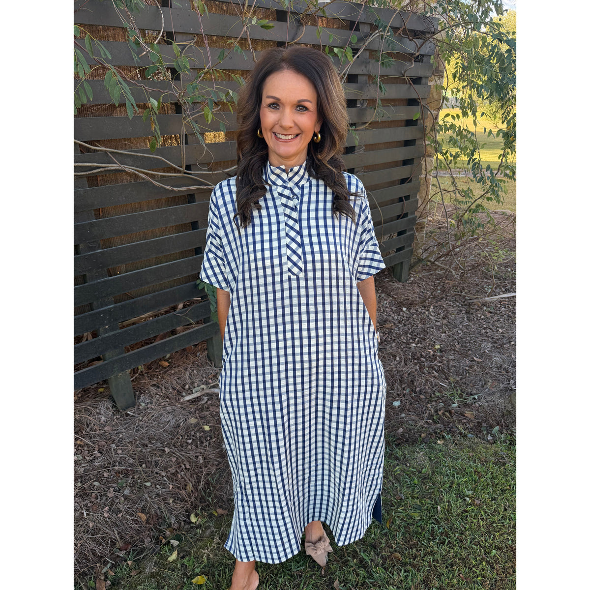 Annie Ks Boutique navy and white gingham midi dress with short sleeves, shirt collar, and pockets on a smiling woman.