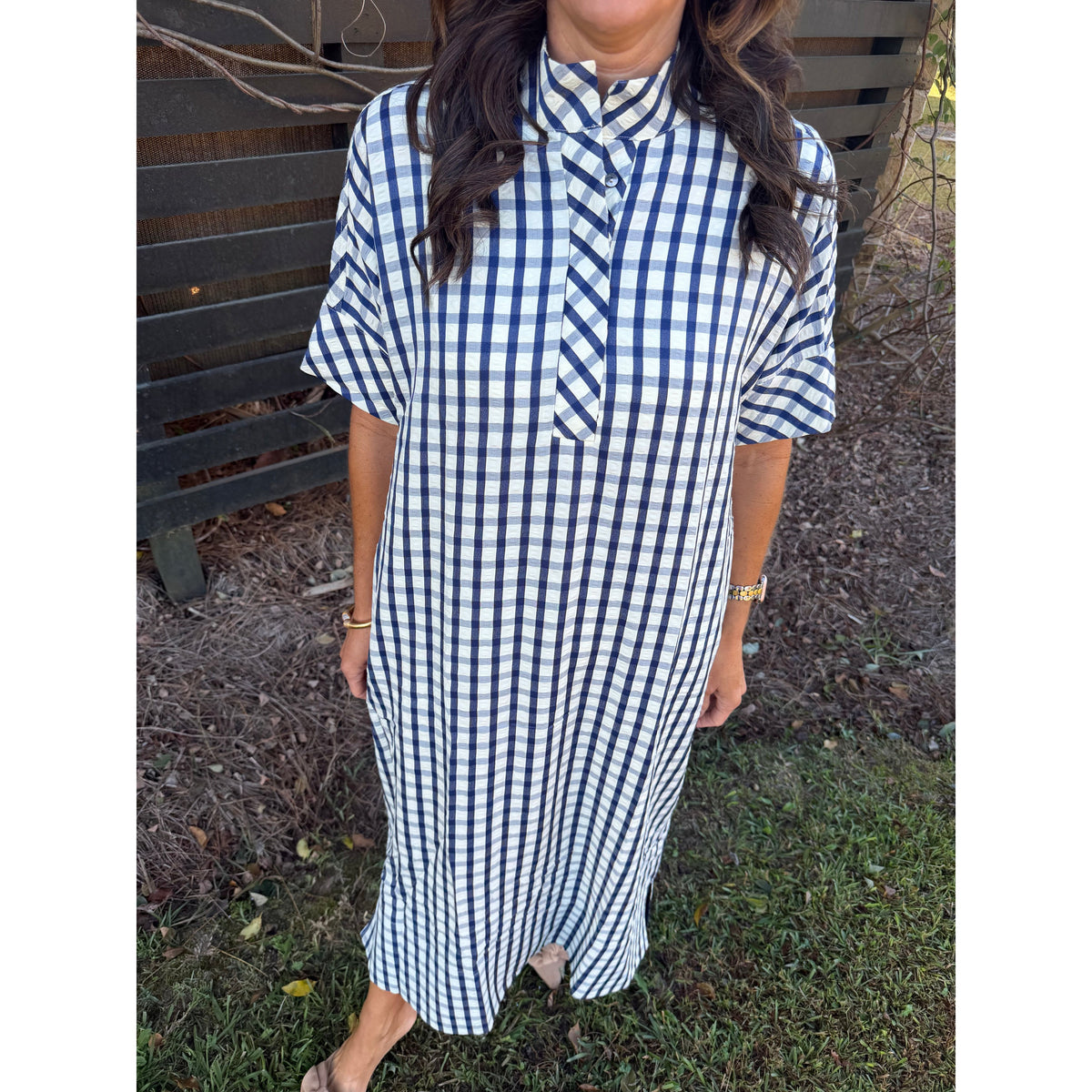 Annie Ks Boutique navy and white gingham midi dress with a shirt collar and short sleeves worn by a woman outdoors.