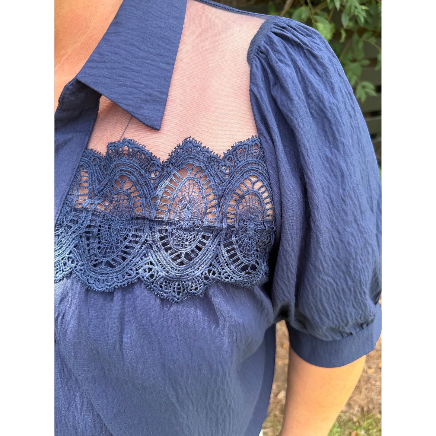 Annie Ks Boutique navy blouse with short puff sleeves, collared neckline, sheer mesh panels, and delicate lace trim.