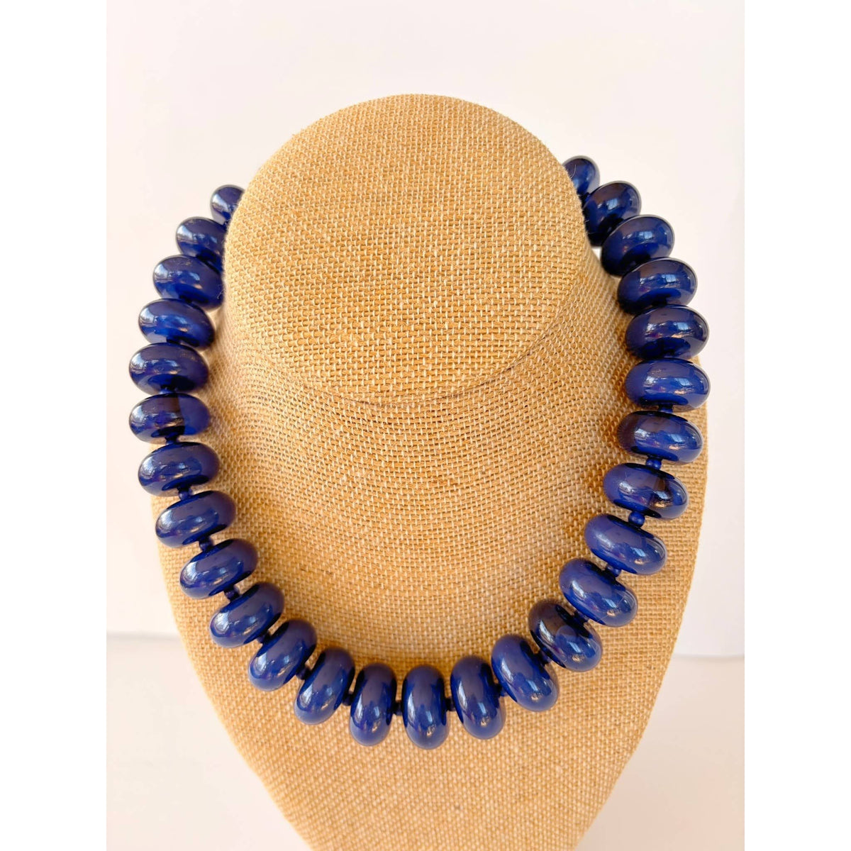 Annie Ks Boutique navy blue large rondelle beaded statement necklace on a beige burlap display bust