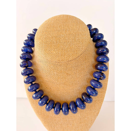 Annie Ks Boutique navy blue large rondelle beaded statement necklace on a beige burlap display bust