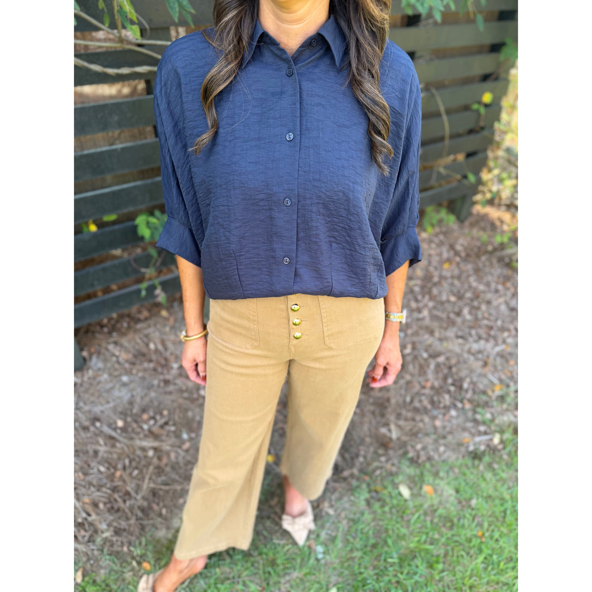 Annie Ks Boutique navy textured short sleeve blouse with dolman sleeves and button-front, paired with tan trousers.