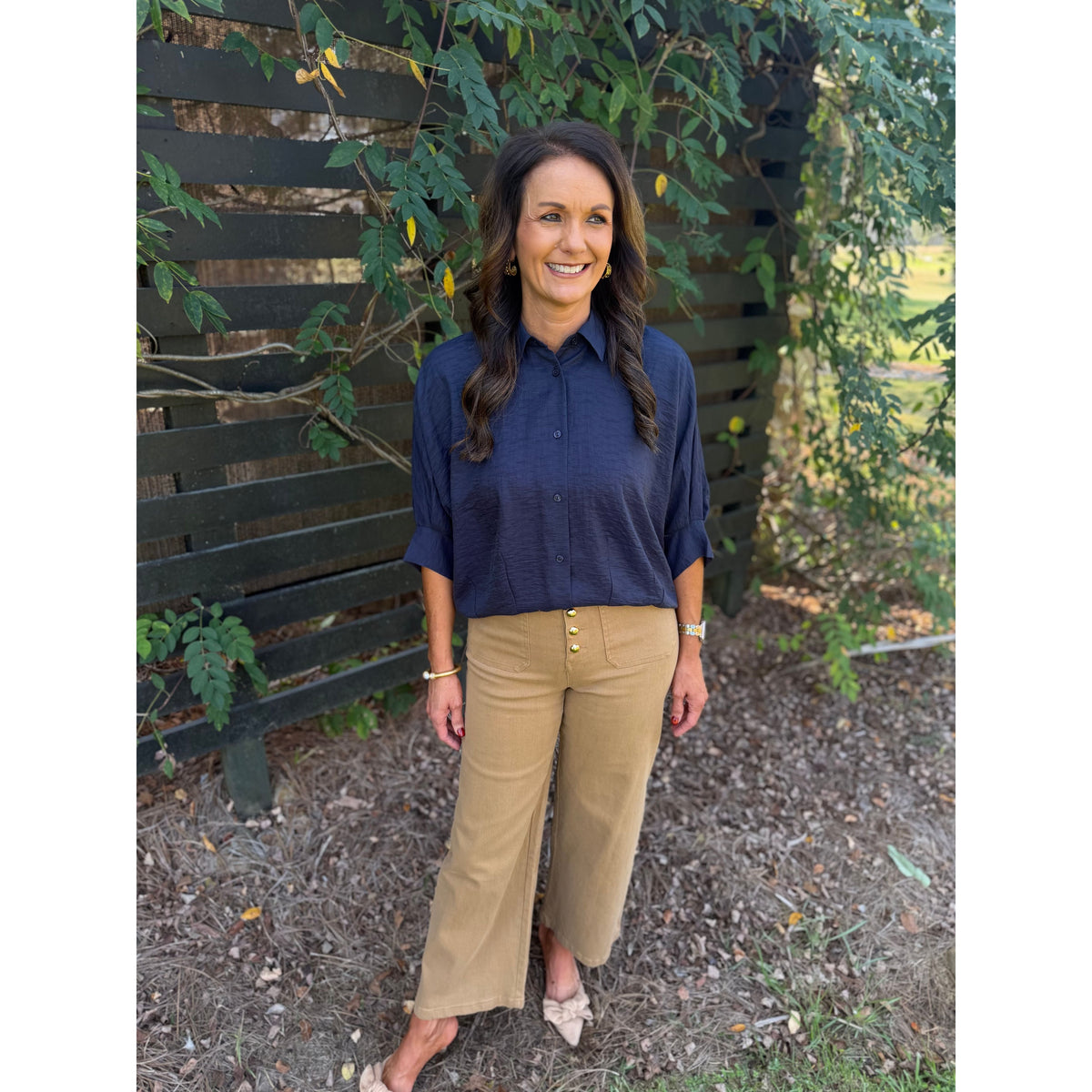 Annie Ks Boutique navy textured short sleeve blouse with a collar and button front, worn with tan cropped trousers.