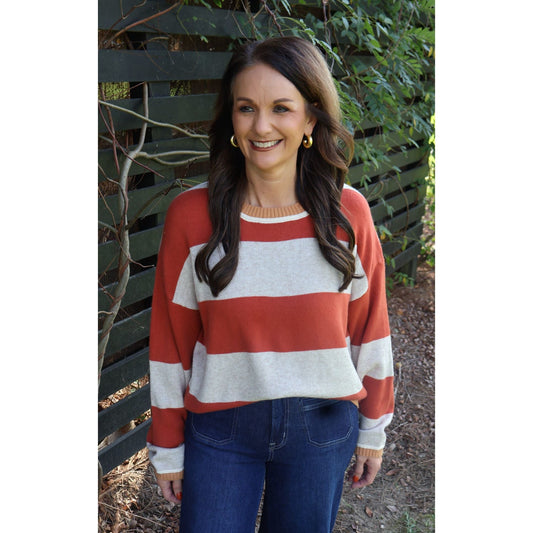 Annie Ks Boutique oatmeal and brick red striped knit sweater with a crew neck worn by a smiling woman outdoors.
