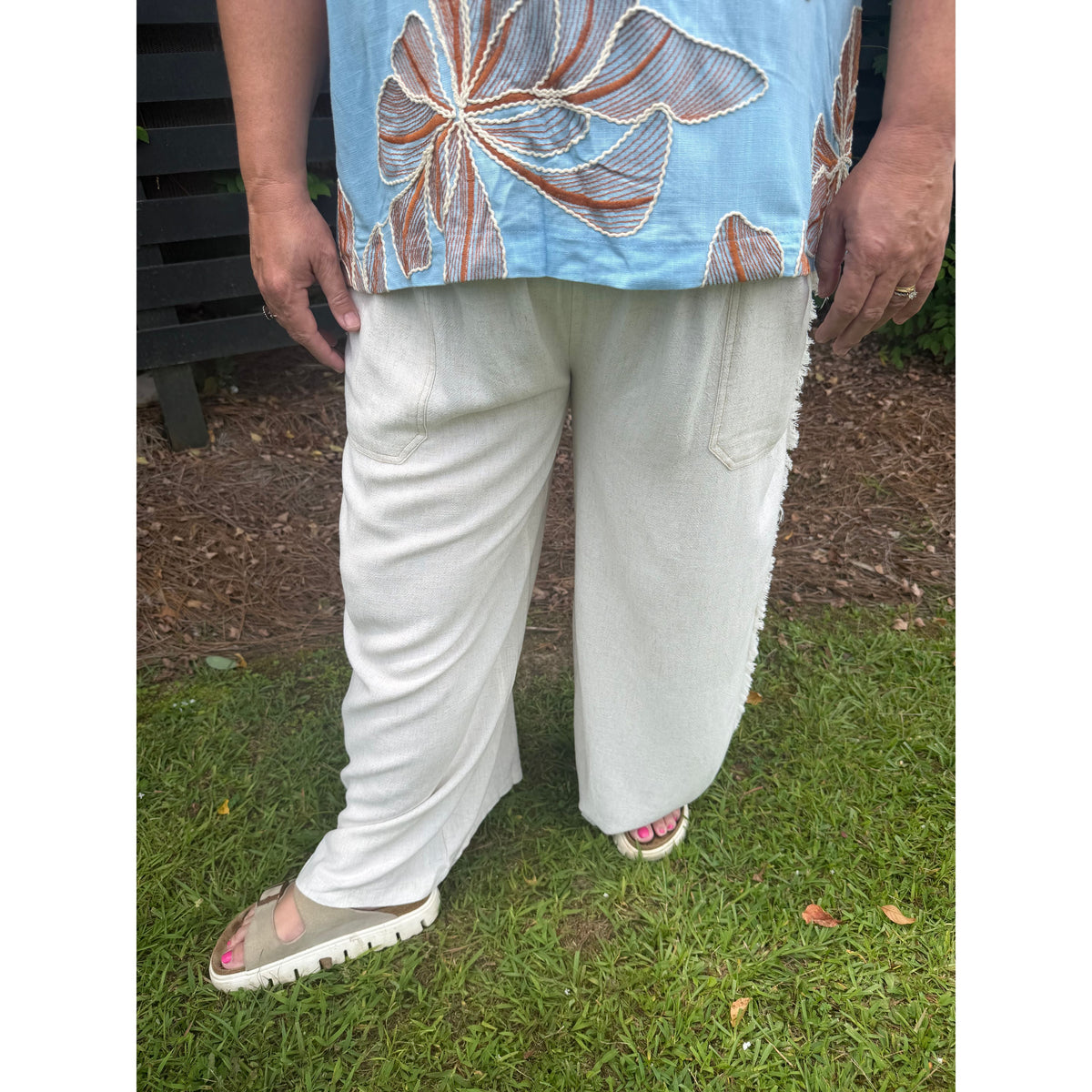Annie Ks Boutique oatmeal linen-cotton wide-leg pants with frayed side seams and patch pockets worn with slides