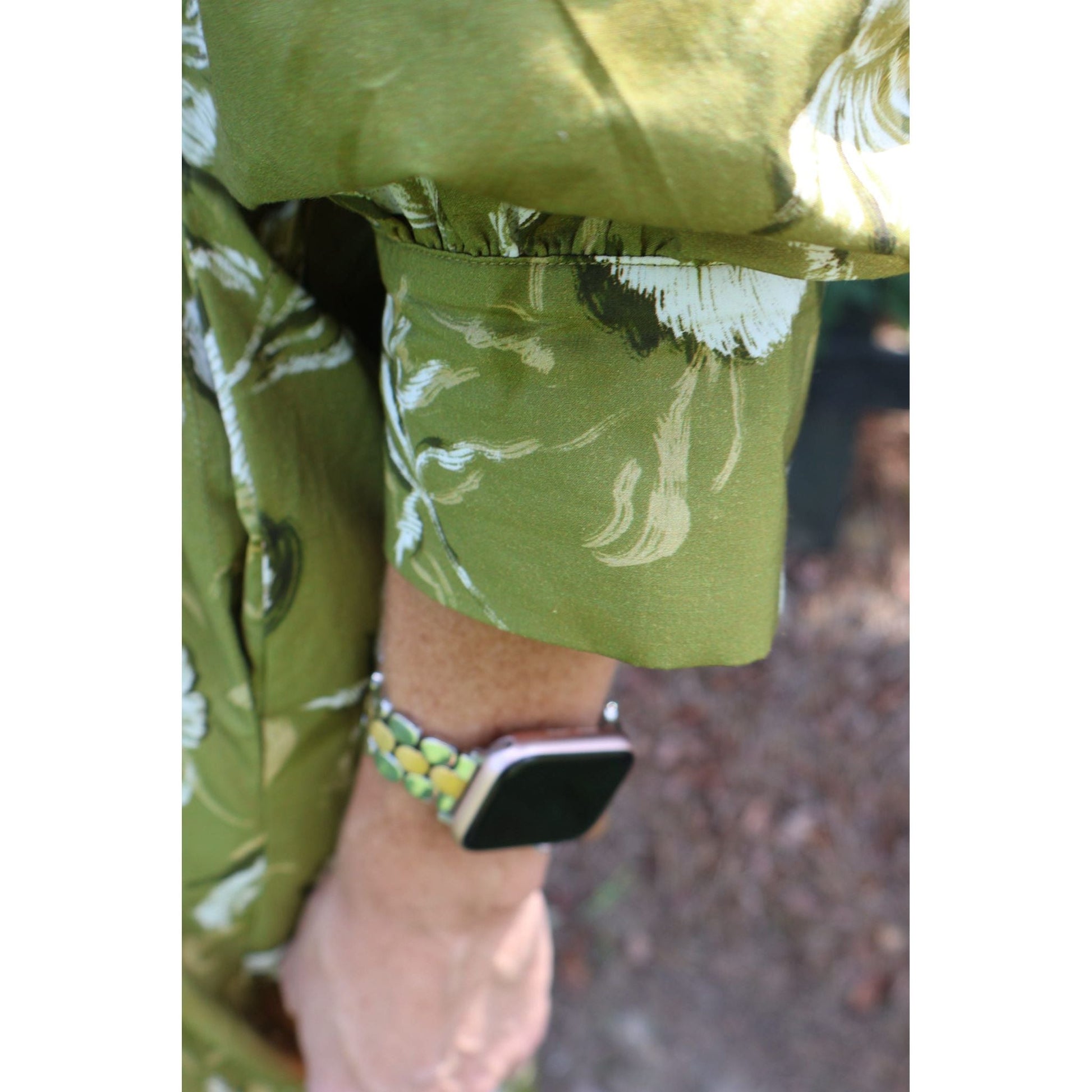 Annie Ks Boutique golden olive floral cotton midi dress sleeve detail with a smartwatch on the wrist