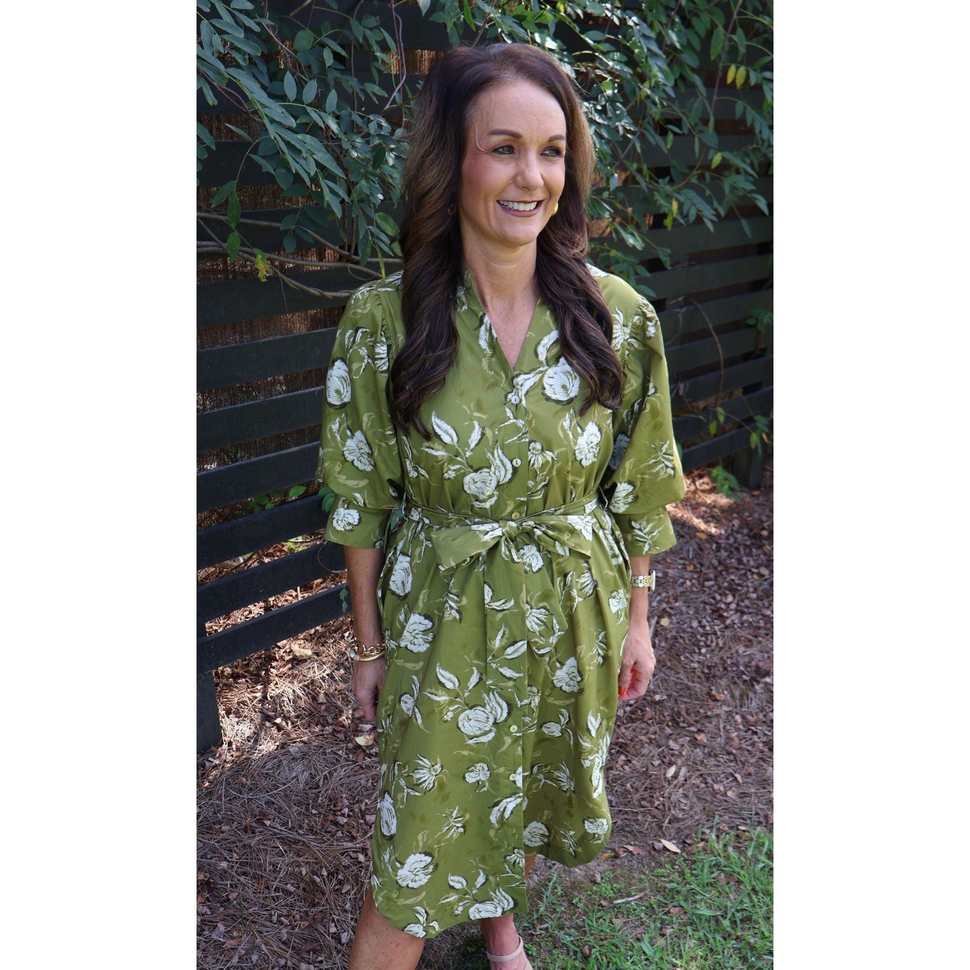 Annie Ks Boutique golden olive floral midi dress with V-neck, half sleeves, and self-tie belt on a smiling woman